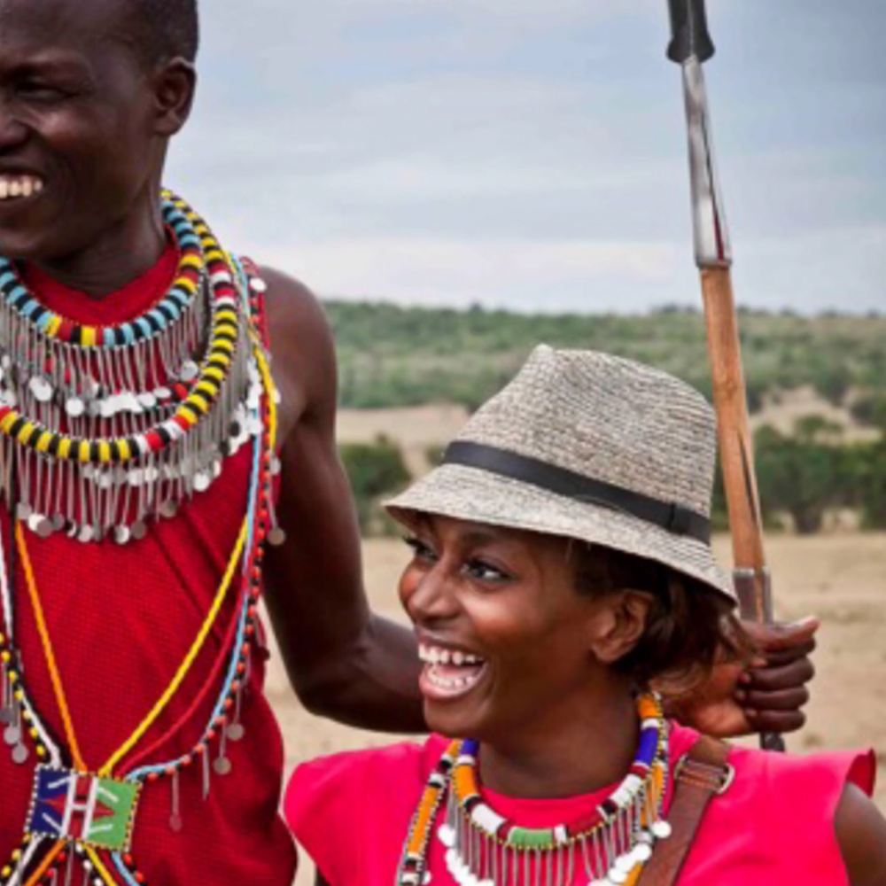 Woman and men smiling in open field